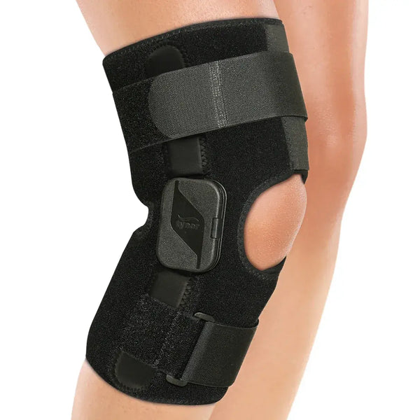 Black knee brace on a person's knee with a white background