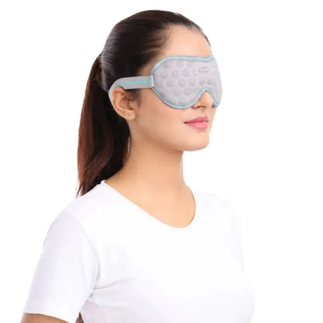 Woman wearing a gray sleep mask on a white background