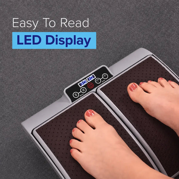 Person using a vibration plate with an LED display on a gray background