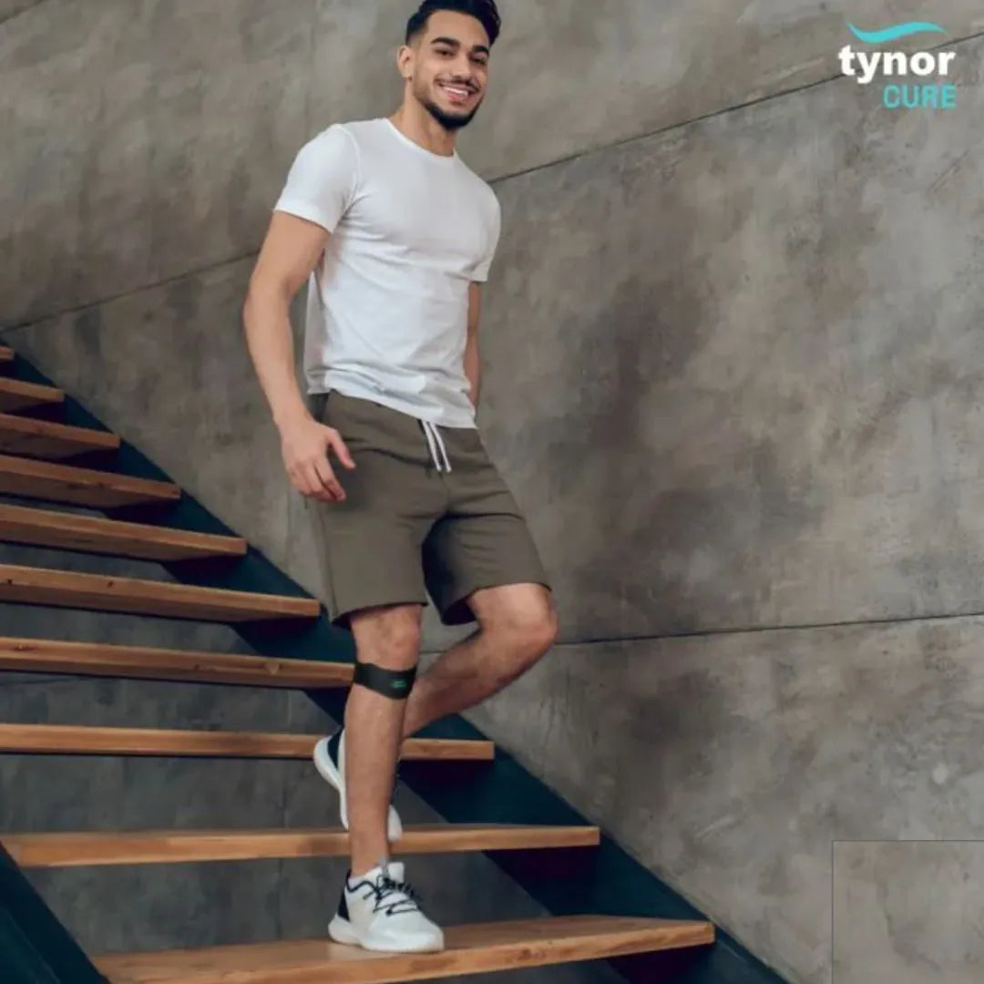 Man walking up a set of stairs wearing a knee brace,