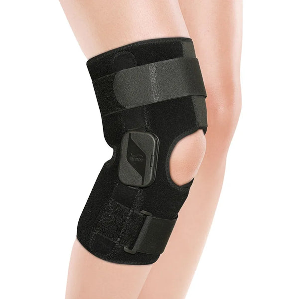 Black knee brace on a person's leg against a white background