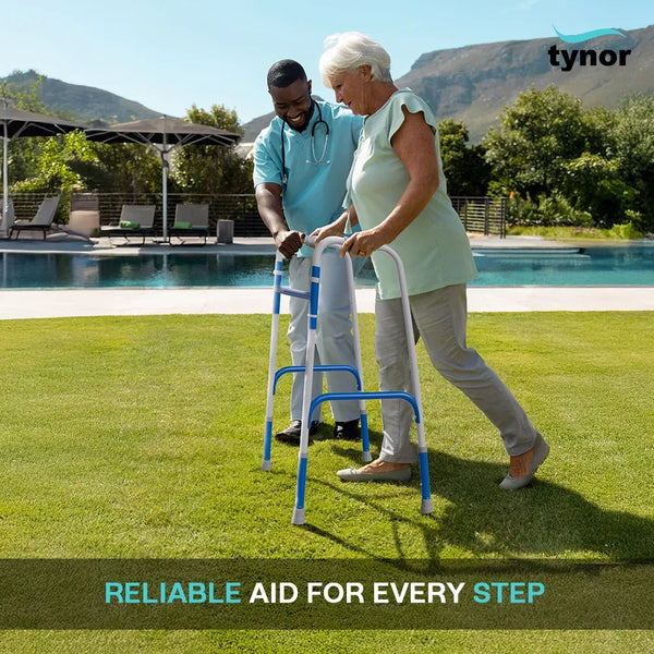 Person using a walker with another person assisting them by a poolside.